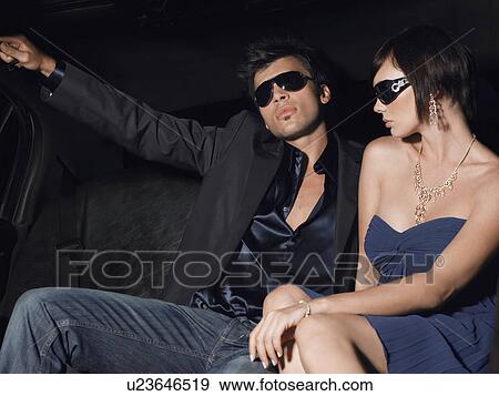 Couple in evening wear and sunglasses in back of limousine View Large Photo Image Stock Photo - Couple in evening wear and sunglasses in back of limousine. Fotosearch