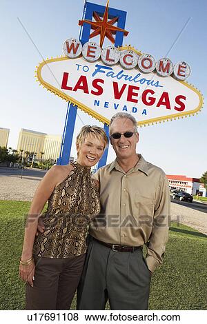 Stock Photo - Couple in front of Welcome to Las Vegas sign portrait. Fotosearch