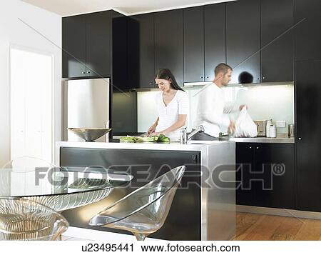 Stock Image - Couple in modern kitchen. Fotosearch