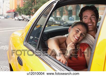 Picture - Couple in yellow taxi cab. Fotosearch