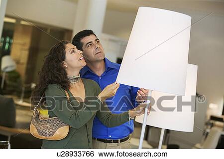 Couple looking at Lamps in furniture store View Large Photo Image Stock Photograph - Couple looking at Lamps in furniture store. Fotosearch
