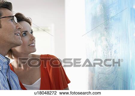 Couple looking at modern art painting in gallery View Large Photo Image Stock Image - Couple looking at modern art painting in gallery. Fotosearch