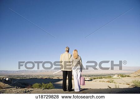 Couple looking at plot for new home back view View Large Photo Image Stock Photo - Couple looking at plot for new home back view. Fotosearch