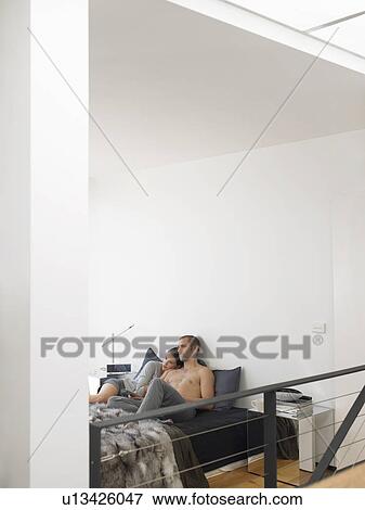Stock Photo - Couple lying on bed. Fotosearch