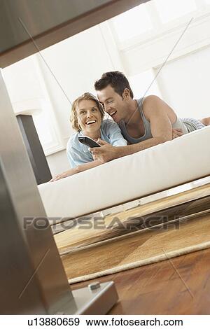 Stock Photo - Couple on bed watching television together. Fotosearch
