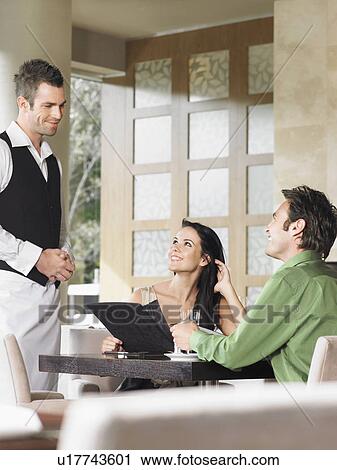 Couple ordering from waiter at outdoor restaurant View Large Photo Image Stock Image - Couple ordering from waiter at outdoor restaurant. Fotosearch