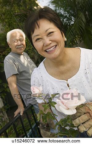 Couple outdoors woman holding roses (portrait) View Large Photo Image Stock Image - Couple outdoors woman holding roses (portrait). Fotosearch