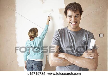 Couple painting interior wall using brush and roller View Large Photo Image Stock Photography - Couple painting interior wall using brush and roller. Fotosearch
