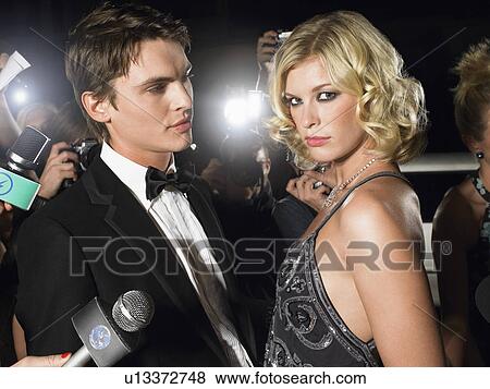 Stock Photo - Couple posing in front of paparazzi. Fotosearch