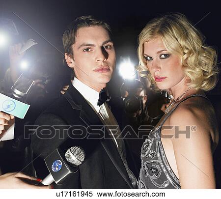 Stock Photography - Couple posing in front of paparazzi. Fotosearch