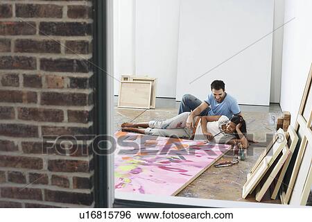 Couple reclining by painting on floor of studio view through window View Large Photo Image Stock Photograph - Couple reclining by painting on floor of studio view through window. Fotosearch