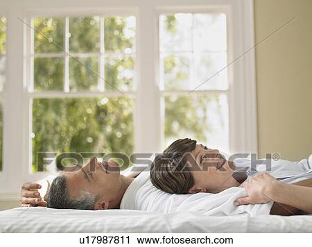 Couple relaxing in bed View Large Photo Image Stock Image - Couple relaxing in bed. Fotosearch