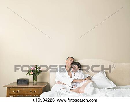 Couple relaxing in bed View Large Photo Image Stock Image - Couple relaxing in bed. Fotosearch