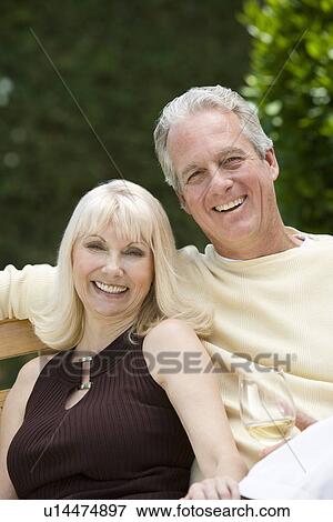 Couple relaxing on bench outdoors portrait View Large Photo Image Stock Photo - Couple relaxing on bench outdoors portrait. Fotosearch