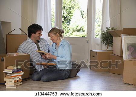 Couple sitting on floor at home with boxes and books View Large Photo Image Stock Image - Couple sitting on floor at home with boxes and books. Fotosearch