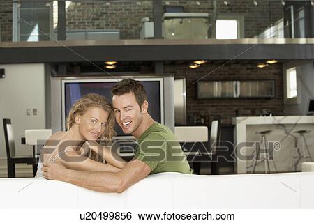 Couple sitting on sofa in modern apartment portrait View Large Photo Image Stock Photograph - Couple sitting on sofa in modern apartment portrait. Fotosearch