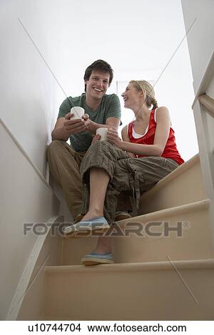 Couple sitting on stairs smiling View Large Photo Image Picture - Couple sitting on stairs smiling. Fotosearch
