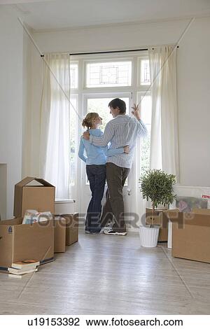 Couple standing by window surrounded by boxes View Large Photo Image Stock Image - Couple standing by window surrounded by boxes. Fotosearch