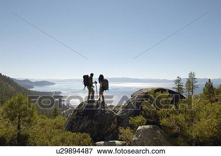 Couple standing on rock at coast View Large Photo Image Stock Photo - Couple standing on rock at coast. Fotosearch