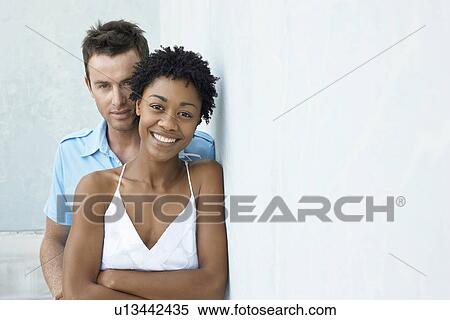 Couple standing together against wall portrait View Large Photo Image Stock Photography - Couple standing together against wall portrait. Fotosearch