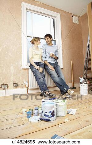 Couple taking a break from painting living room View Large Photo Image Stock Photography - Couple taking a break from painting living room. Fotosearch