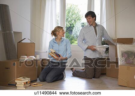 Couple unpacking boxes at home View Large Photo Image Picture - Couple unpacking boxes at home. Fotosearch