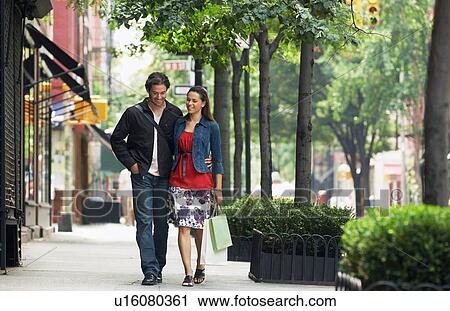 Couple walking on sidewalk View Large Photo Image Stock Image - Couple walking on sidewalk. Fotosearch