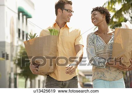 Couple walking with groceries portrait View Large Photo Image Stock Photo - Couple walking with groceries portrait. Fotosearch