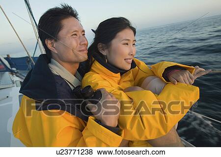 Couple wearing yellow anoraks on yacht View Large Photo Image Stock Photo - Couple wearing yellow anoraks on yacht. Fotosearch