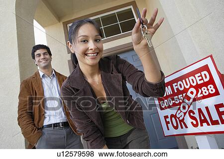 Stock Photo - Couple with keys to new home. Fotosearch