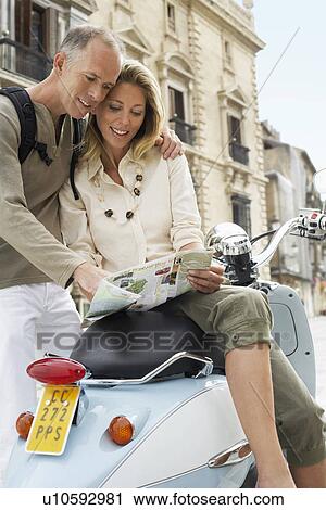 Couple With Scooter Reading Map on old street in Granada Spain View Large Photo Image Stock Image - Couple With Scooter Reading Map on old street in Granada Spain. Fotosearch