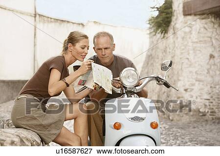 Couple With Scooter Reading Map on old street in Granada Spain View Large Photo Image Stock Photo - Couple With Scooter Reading Map on old street in Granada Spain. Fotosearch