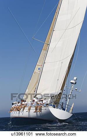Crew sitting on Side of sailboat side view View Large Photo Image Stock Image - Crew sitting on Side of sailboat side view. Fotosearch