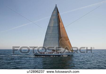 Stock Photo - Crew sitting on side of sailboat side view. Fotosearch