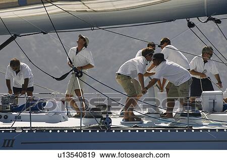 Stock Photo - Crew working on yacht side view. Fotosearch