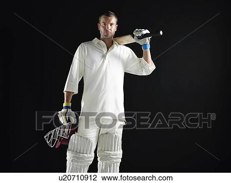 Cricket player standing holding cricket bat on shoulder View Large Photo Image Stock Image - Cricket player standing holding cricket bat on shoulder. Fotosearch