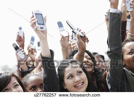 Crowd holding up cell phones head and shoulders View Large Photo Image Stock Photo - Crowd holding up cell phones head and shoulders. Fotosearch