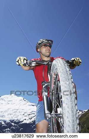 Cyclist riding by mountains View Large Photo Image Stock Photo - Cyclist riding by mountains. Fotosearch