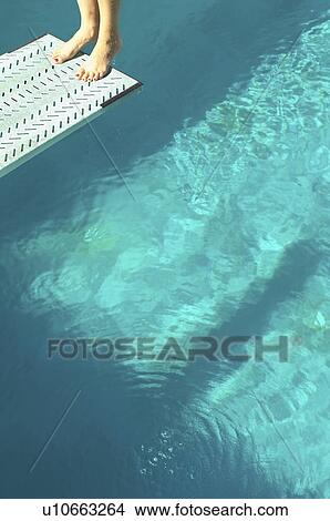 Picture - Diver standing backwards at the end of diving board over pool low section. Fotosearch