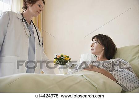 Stock Photo - Doctor talking to Patient in Hospital Bed. Fotosearch