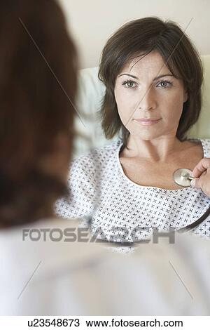 Doctor using stethoscope on chest of patient back view of doctor focus on patient View Large Photo Image Stock Image - Doctor using stethoscope on chest of patient back view of doctor focus on patient. Fotosearch