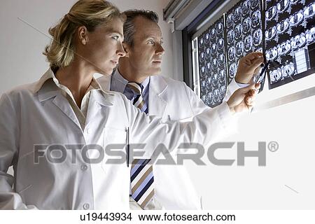 Doctors Examining brain scans in hospital side view View Large Photo Image Picture - Doctors Examining brain scans in hospital side view. Fotosearch