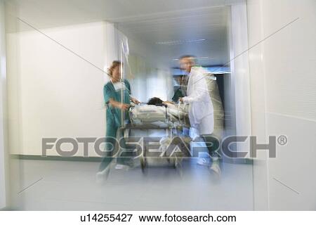 Doctors Moving Patient on gurney through hospital corridor motion blur View Large Photo Image Stock Photo - Doctors Moving Patient on gurney through hospital corridor motion blur. Fotosearch