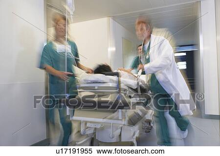 Doctors running Patient on gurney through hospital corridor motion blur View Large Photo Image Stock Photography - Doctors running Patient on gurney through hospital corridor motion blur. Fotosearch