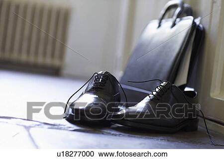Stock Image - Dress Shoes and briefcase on domestic Hallway floor close up. Fotosearch