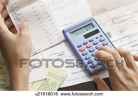 Stock Photograph - Expenses being calculated. Fotosearch