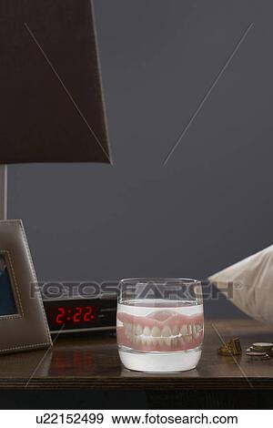 False teeth in glass on bedside cupboard View Large Photo Image Stock Photo - False teeth in glass on bedside cupboard. Fotosearch