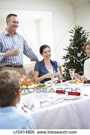 Stock Photography - Family at table at christmas dinner. Fotosearch