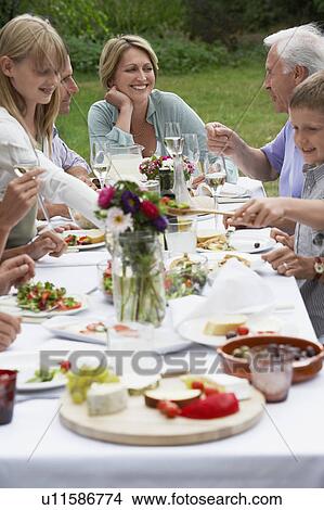 Family dining in garden View Large Photo Image Picture - Family dining in garden. Fotosearch