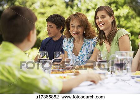 Family having meal at table in back yard View Large Photo Image Stock Image - Family having meal at table in back yard. Fotosearch